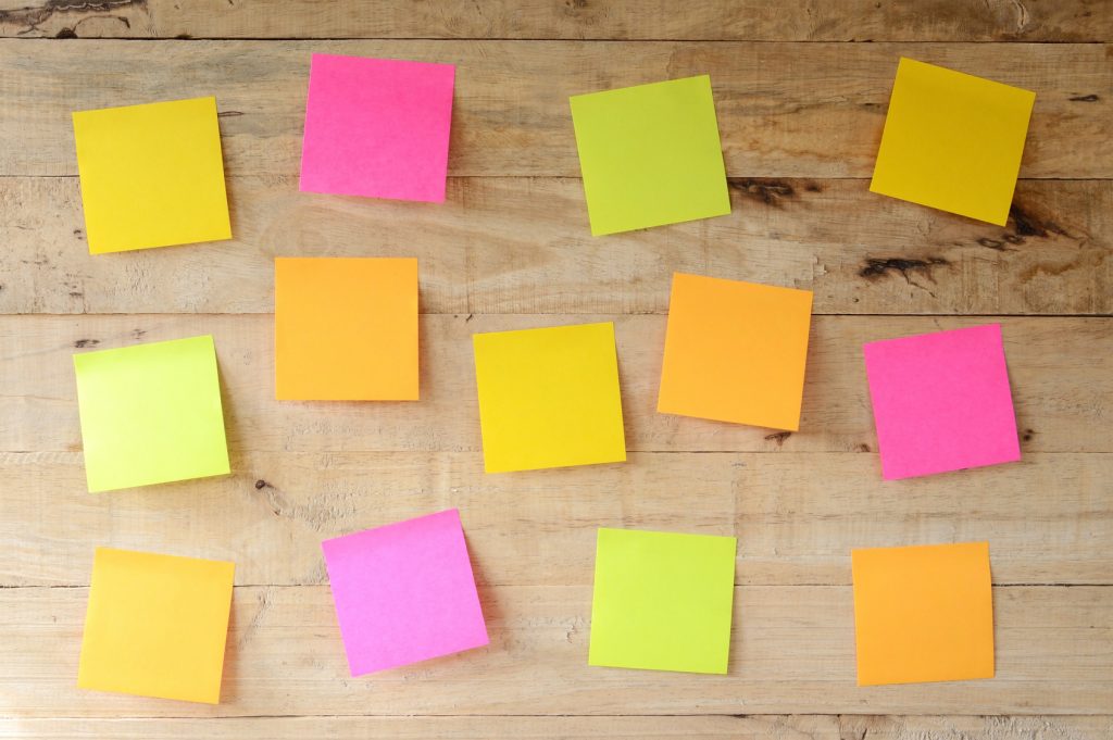 empty colorful sticky notes on wooden bulletin board, ready for message
