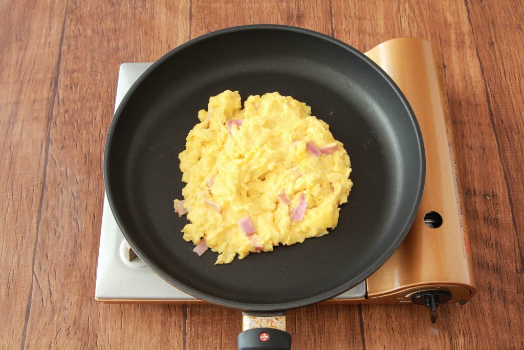 フライパンにバターを入れて中火で熱し、溶けたら卵液を流し入れ、ゴムベラで大きく混ぜて半熟状のスクランブルエッグを作る。