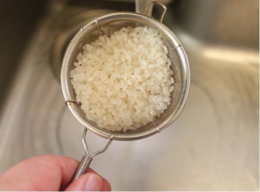 小鍋に米と水、塩を入れる。米は少量のため、茶こしでに入れて一緒にあらうと楽です。