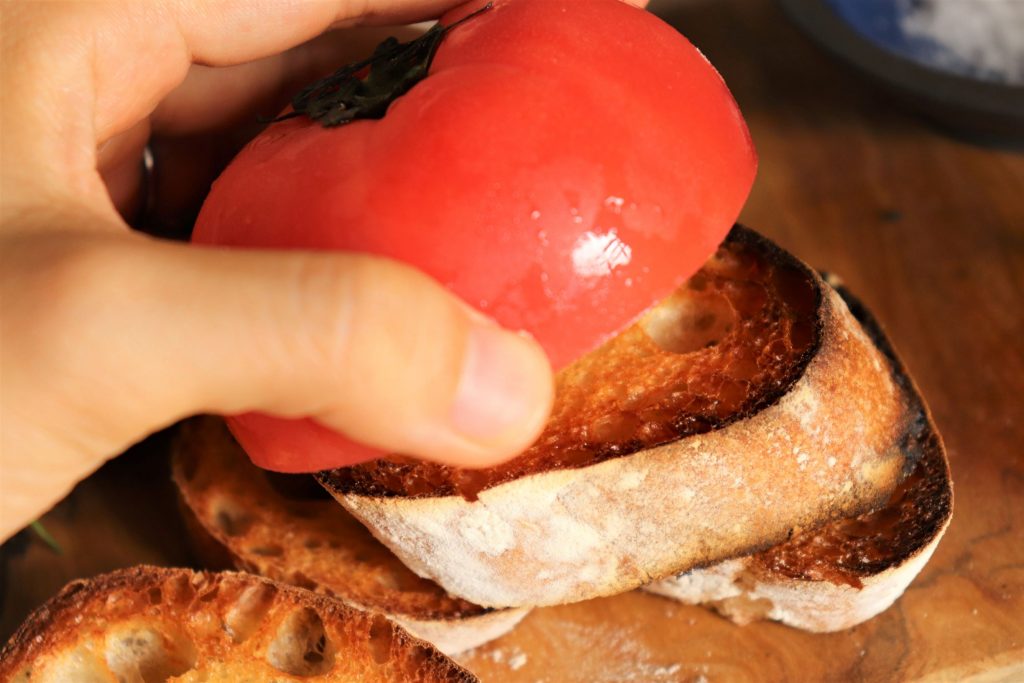 半分に切ったトマトをパンにこすりつける。