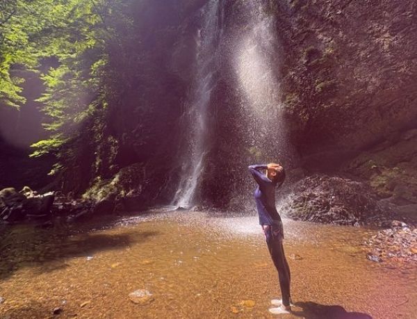 滝の前に立つ女性