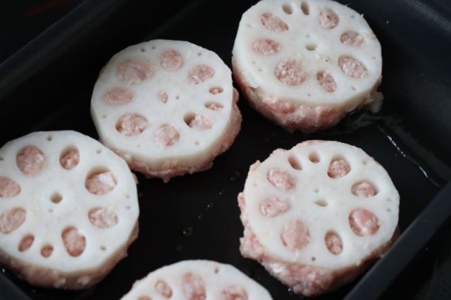 フライパンに並べたれんこんの肉詰め