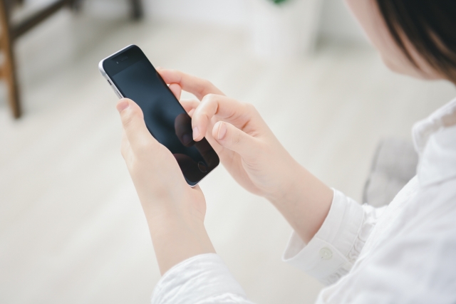 スマホを触る女性の手元