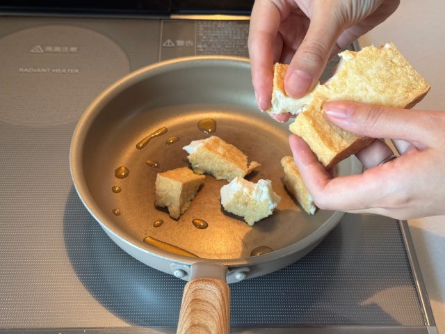 厚揚げを手でちぎって入れる
