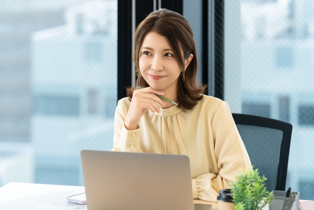 笑顔でペンを持つ女性