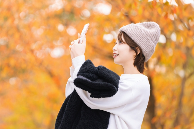 紅葉の写真を撮る女性