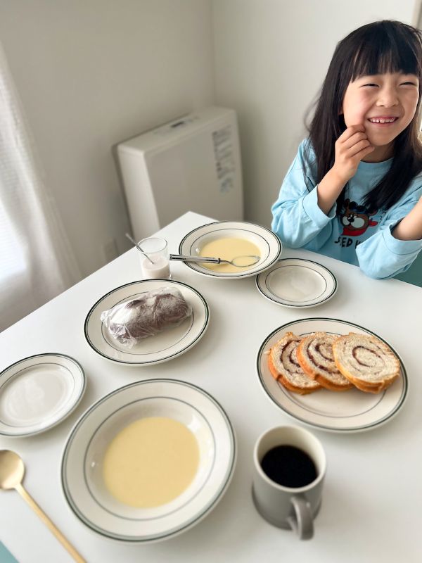 にっこり微笑む女の子とスープの朝食