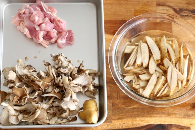 バットに並べた鶏もも肉とごぼうと舞茸
