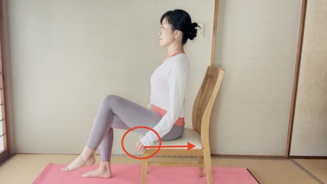 椅子の座面を握る女性