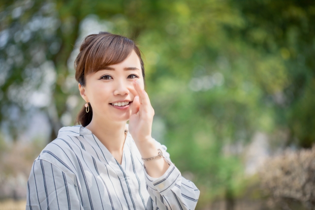 笑顔でこっそり話そうとする女性