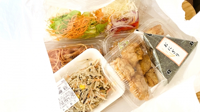 レジ袋に入ったお惣菜とおにぎり