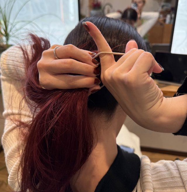 一つ結びする女性の手