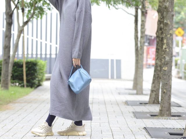 ワンピースとスニーカーで歩く女性