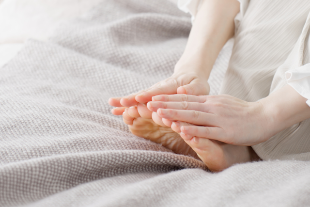 足に手を当てる女性