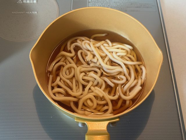 ゆでうどんをほぐし入れる