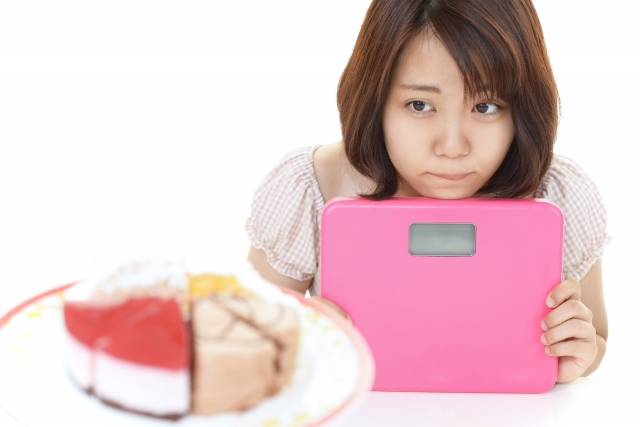 体重計を持った女性