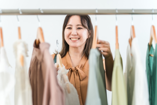 洋服を選ぶ笑顔の女性