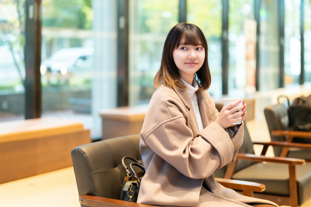 飲み物を持って微笑む女性