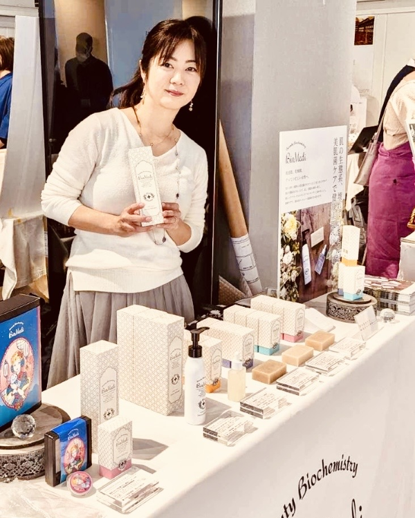 スキンケアアイテムを持つ岡本さん