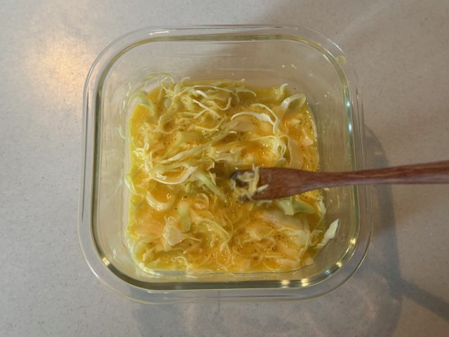 卵と千切りキャベツを混ぜる