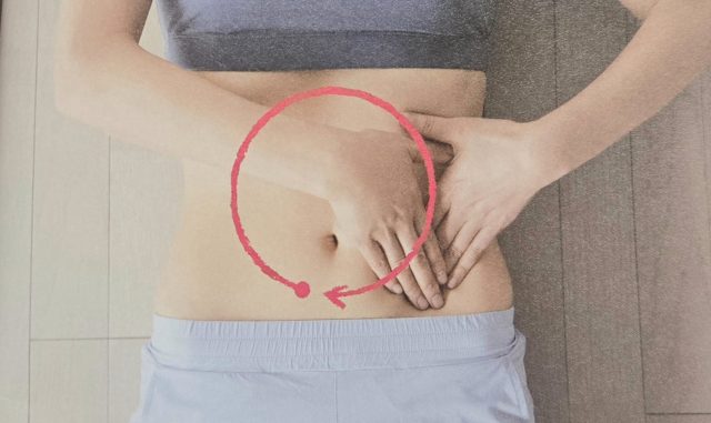 お腹を手で押さえる