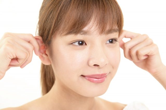 耳のマッサージをする女性