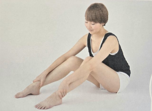 体育座りの女性