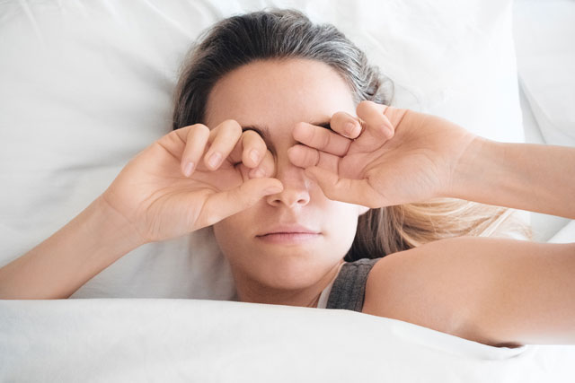 目をおさえる女性