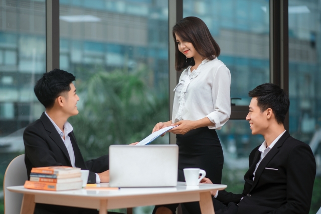 資料を男性に渡す女性