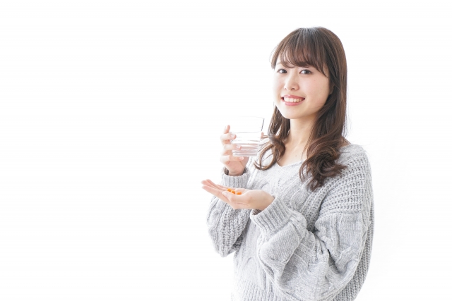 サプリメントを飲む女性