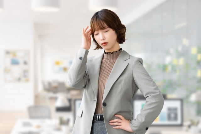 頭を押さえて悩む女性・ビジネスウーマン