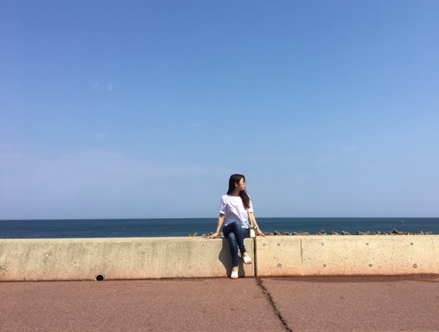 青空の下座る女性