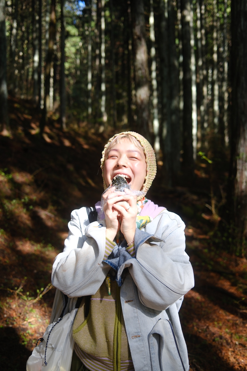 外でおにぎりを食べる女性