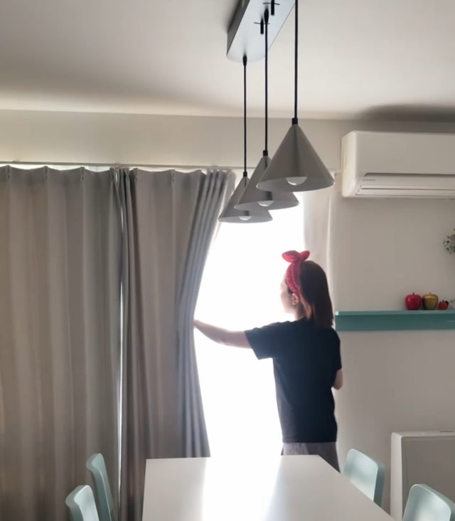 カーテンを開ける女性