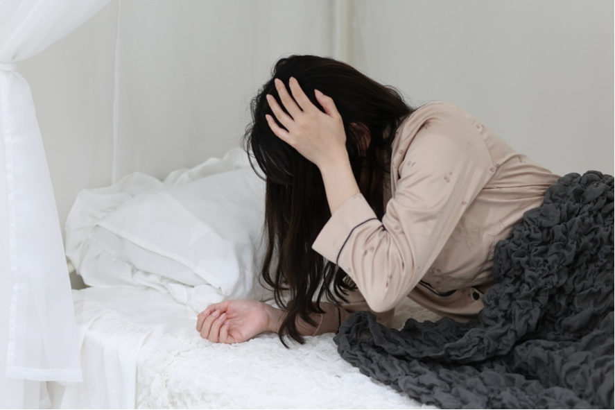 頭を押さえる女性