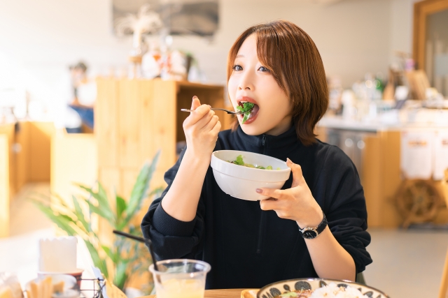 カフェでサラダを食べる女性