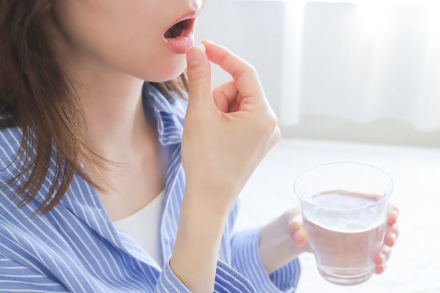 サプリを飲む女性