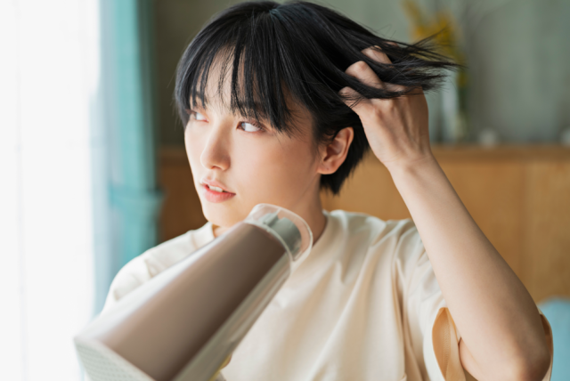 ドライヤーをかける女性