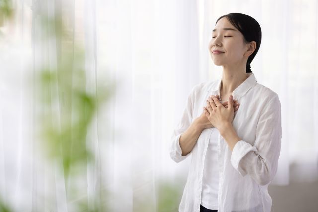 胸に手を当てる女性