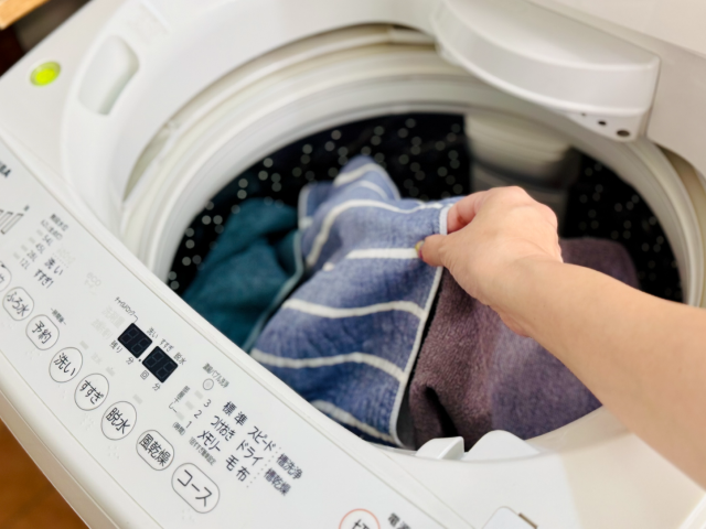 洗濯機に洗濯物を入れる