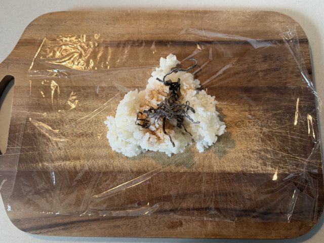 ごはんに塩昆布としょうゆを加える様子
