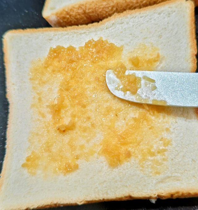 パンに生姜味噌を塗っている様子